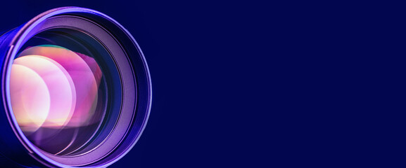 Banner. The camera lens with blue light and refractions. Close-up of the camera lens on a black...