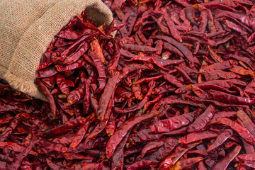 Dried red hot chili peppers in a sack of food ingredients Isolated on white background.