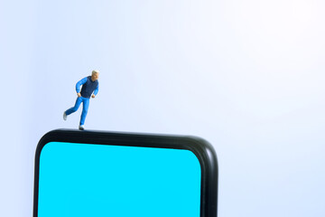 Running and jogging tracking app concept. A men running above smartphone. Miniature people figure photography.