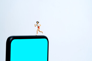 Running and jogging tracking app concept. A men running above smartphone. Miniature people figure photography.