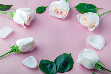 Flat lay flowers composition for your lettering. Frame made of white rose flowers on pink  background. Invitation greeting card. Top view, copy space for text, mock up. Holiday concept