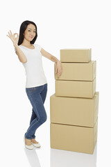 Woman with a stack of gift boxes, showing hand gesture