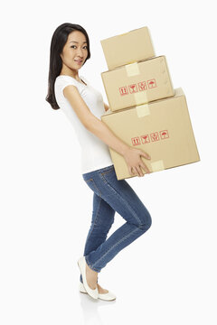 Woman carrying a stack of cardboard boxes