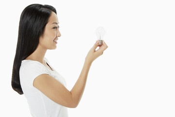 Woman holding up a light bulb