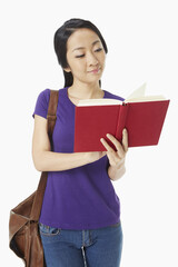 Woman reading a book while standing