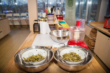Kitchen interior with various dishes and two pots of asparagus.