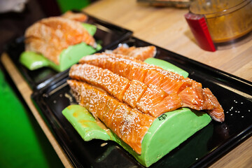 Salmon with seasoning and sesame is prepared for cooking.