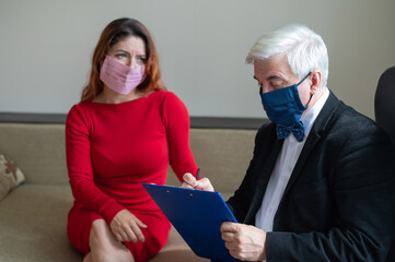 Male psychotherapist advises a female client in a medical mask. Moral support during the epidemic....