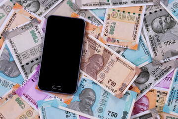Mobile smart phone and indian rupee notes, digital money,fin-tech,money making online concepts.