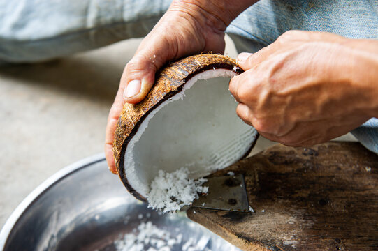 The chef is scraping the coconut to make coconut milk.