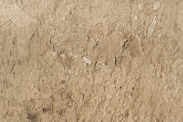 old beige wall with a damaged, rough and dirty texture in the surface - wallpaper background