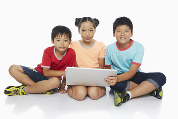 Three children using a laptop together