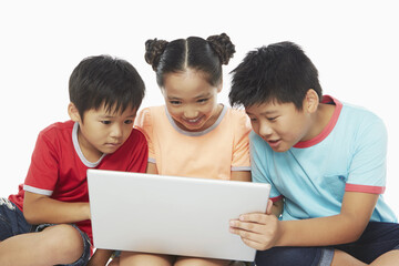 Three children using a laptop together