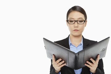 Serious businesswoman reading notes from a folder