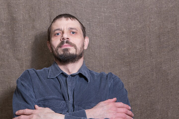 Confident man looking at the camera. Calm look. Casual wear. Background from the canvas. A...