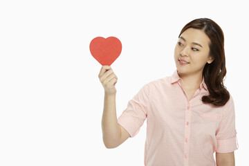 Cheerful woman holding up a red heart