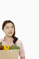 Cheerful woman with a bag of groceries