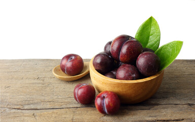 Fresh plum on wooden table against white