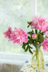 Pink peonies in vase on the table. country still life