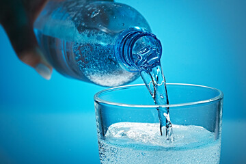 Mineral water is poured into a glass.