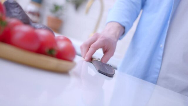 Сhef is taking the leather case and pulls out the knife. The chef is juggling a knife in the kitchen. A trick with a carving knife above the table.