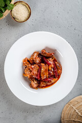 Fried pork ribs in pepper sauce in a white plate