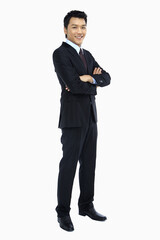 Cheerful businessman standing with arms crossed