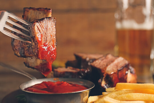 Eating Of Tasty Beef Short Ribs With Sauce And French Fries, Closeup