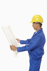 Construction worker looking at a blueprint plan