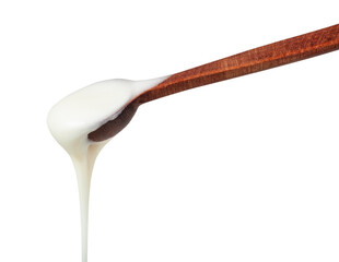 side view of natural organic white honey pouring from little wooden spoon closeup isolated on white...