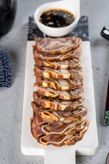 Pork legs with sauce on a white long board