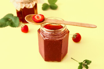 Jar of tasty strawberry jam on color background