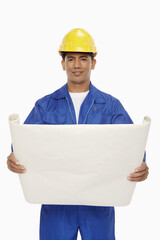 Construction worker looking at a blueprint plan