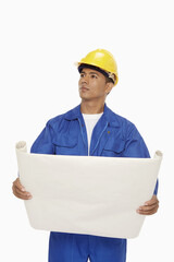 Construction worker looking at a blueprint plan