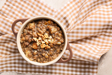 Pot of tasty lentils soup on table