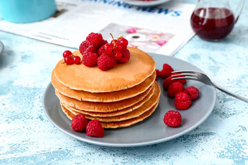 Sweet pancakes with berries on color background