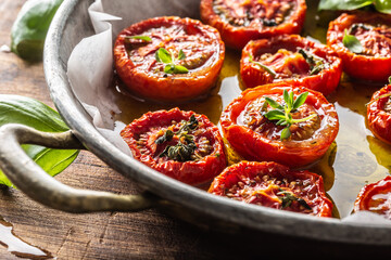 Roasted tomatoes with olive oil thyme oregano and basil in pan
