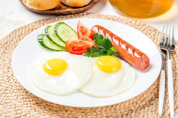 Breakfast of fried eggs, sausages and fresh vegetables