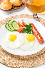 Breakfast of fried eggs, sausages and fresh vegetables