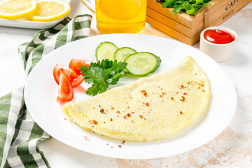 Breakfast omelet with vegetables on a white, round plate