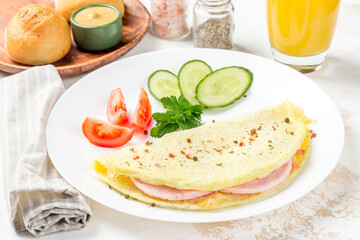 Breakfast omelet with vegetables on a white, round plate