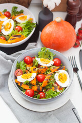 Vegetable salad with grilled carrot, cherry tomatoes, pumpkin, lettuce, boiled eggs and sesame seeds.