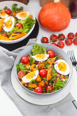 Vegetable salad with grilled carrot, cherry tomatoes, pumpkin, lettuce, boiled eggs and sesame seeds.