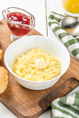 Breakfast millet porridge with butter and jam in a white plate