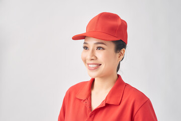Smiling delivery woman in red uniform standing with arm crossed - isolated on white background