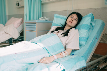 medicine healthcare and people concept. tired asian japanese woman lying on bed at hospital ward....