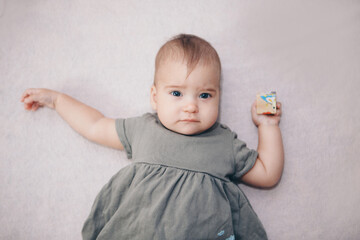 Naklejka premium portrait of a child with a child's cube. the girl is playing. Concept of fine motor skills development, educational games, childhood, children's day, kindergarten copyspace