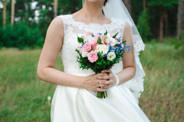 Obraz na płótnie Canvas bride holding bouquet, the bride's bouquet, bride in wedding dress, bouquet of roses, wedding day