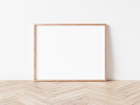 Horizontal rose gold empty frame on wooden floor. Copper frame mock up. 3D illustration.