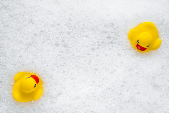 High Angle View Of Yellow Rubber Duck In Bath Swimming In Foam Water. Yellow Rubber Ducklings In Soapy Foam.